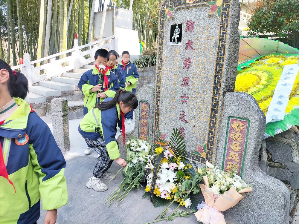 学生在郑大芳烈士墓前敬献鲜花。（受访单位供图）