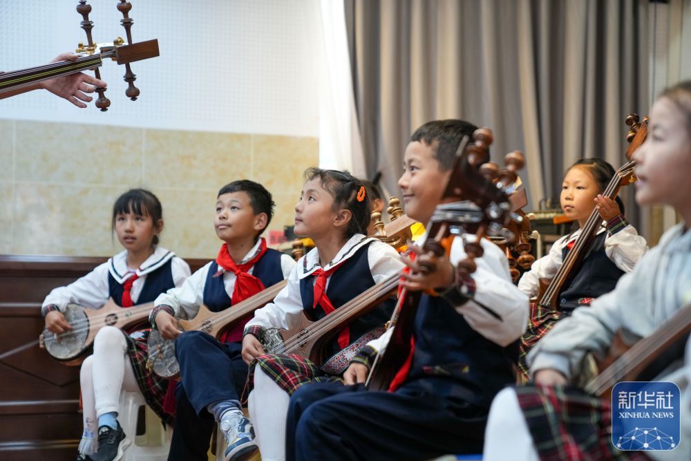 ↑ 9月11日，在拉萨市实验小学，孩子们在弹奏扎念琴。