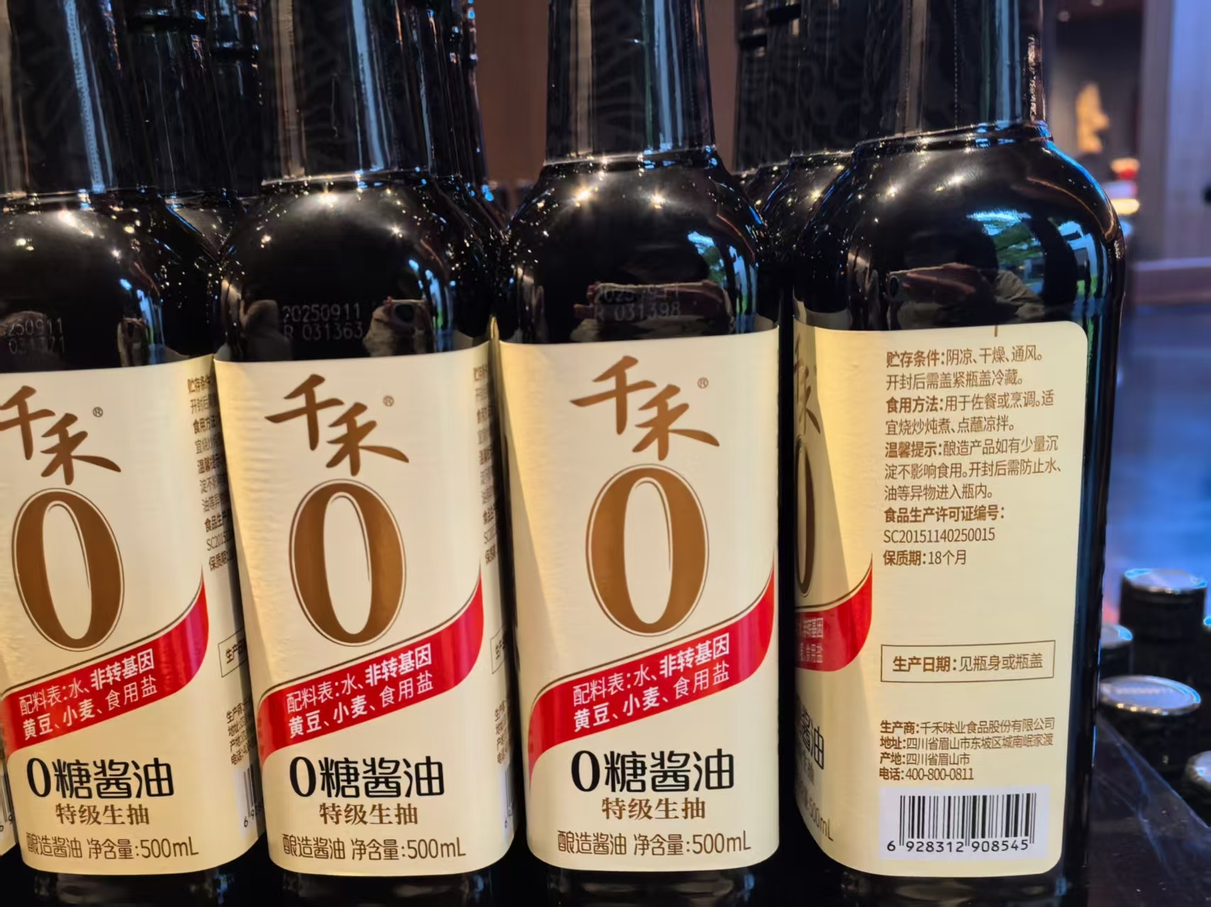 相较于旧版产品，新版产品将配料表以红底白字标示于瓶身正面。（郑明珠/摄）