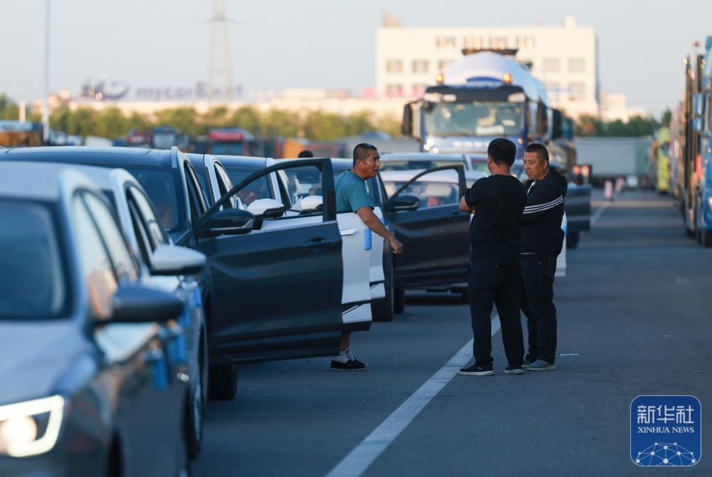 傍晚,在新疆霍尔果斯公路口岸海关集中查验场,“摆渡人”在等待出关(5月27日摄)。