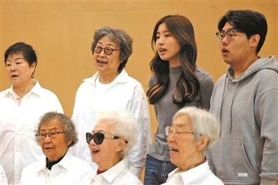 社区金色麦子合唱团日常排练歌曲《向云端》,音乐治疗师田昕田(后右二)、中央音乐学院音乐治疗专业在读生焦诗昂(后右一)与老人们合唱