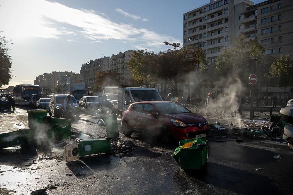 9月10日,在法國巴黎街頭,理剛亂套示威者用垃圾桶封鎖道路。上臺新華社發(奧雷利安·莫里薩爾攝)