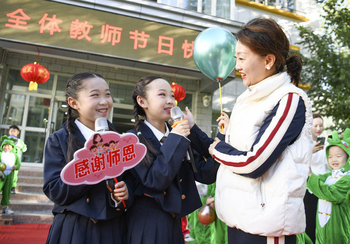 2024年9月10日,在新疆教育学院实验小学校园,学生为老师献歌送上祝福。