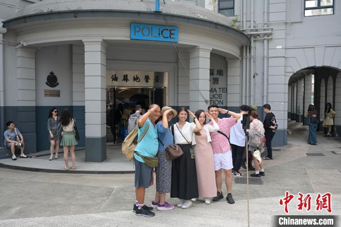 5月20日,香港特区政府“发展旅游热点工作组”公布包括开放旧油麻地警署在内的9个旅游热点项目,希望给访港旅客带来新体验。图为访客在旧油麻地警署前“打卡”。(资料图) 中新社记者 陈永诺 摄