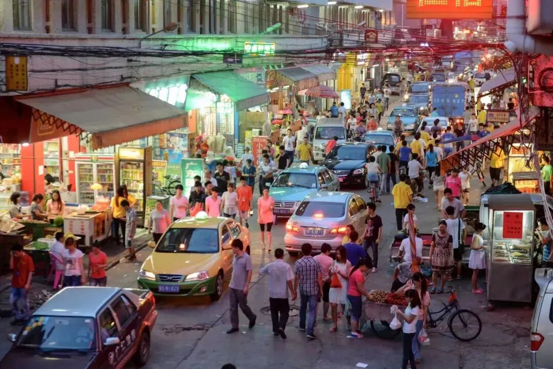 一家玩具厂的员工交接班时刻,上班和下班的人交织在马路上