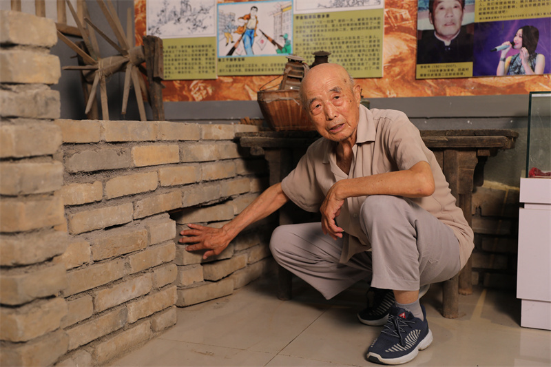 图3:7月2日,李智凛在李家小院,演示土炕下的地道口模型。.jpg