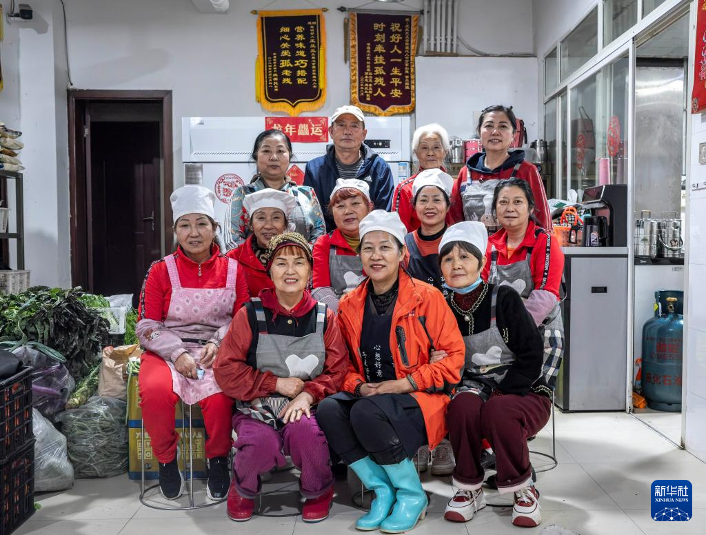 在昆明市幸福家园小区爱心食堂,王兰兰(前中)和义工们合影(5月28日摄)。