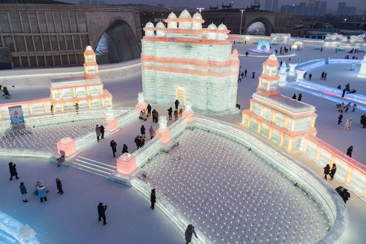 2023年2月1日,游客在哈尔滨冰雪大世界园区冰雪景观《胜利之城》周边游玩,该冰雪景观以印度的法塔赫布尔西格里城为原型设计建造(无人机照片)。此届哈尔滨冰雪大世界将上合组织成员国的特色建筑以冰雪景观的形式呈现。新华社记者 谢剑飞 摄