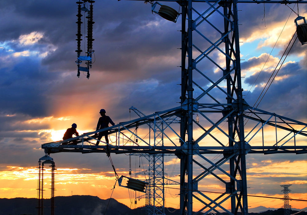 10月6日,在湖南省衡阳市雁峰区南三环路上,湖南雁能建设集团有限公司的施工人员在高塔进行架线施工作业(无人机照片)。新华社发(曹正平摄)