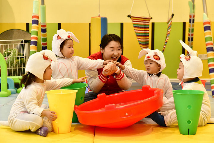 2025年2月20日，在山东省日照市东港区知子树托幼园，老师陪伴孩子做游戏。新华社记者 郭绪雷 摄