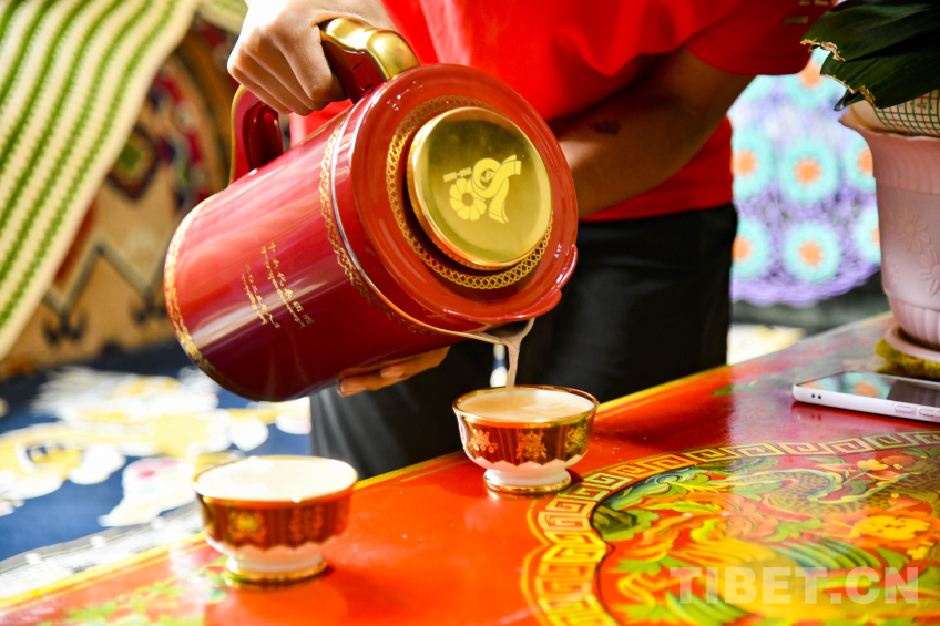 图为罗布次仁为母亲卓嘎倒上第一杯酥油茶,这对茶杯是西藏自治区成立50周年中央代表团赠送的礼物 摄影:赵振宇