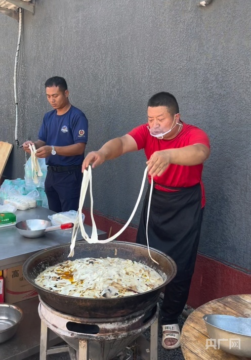 赵占胜(右)正在为村民煮烩面(央广网发 受访者供图)
