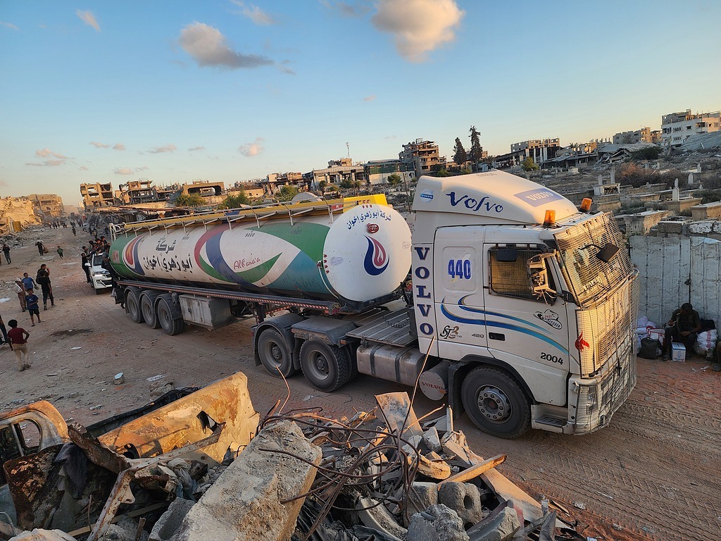 当地时间2025年10月12日,根据停火协议,载有人道主义援助物资和燃料的卡车通过凯雷姆沙洛姆口岸进入加沙地带,抵达汗尤尼斯。