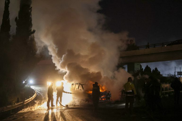 当地时间14日，消防员在通往贝鲁特机场的道路上扑灭一辆被抗议者纵火焚毁的联黎部队车辆。图源：法媒