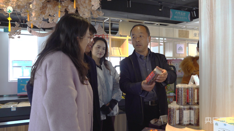 朱学向游客推介当地物产(央广网记者 寇刚 摄)