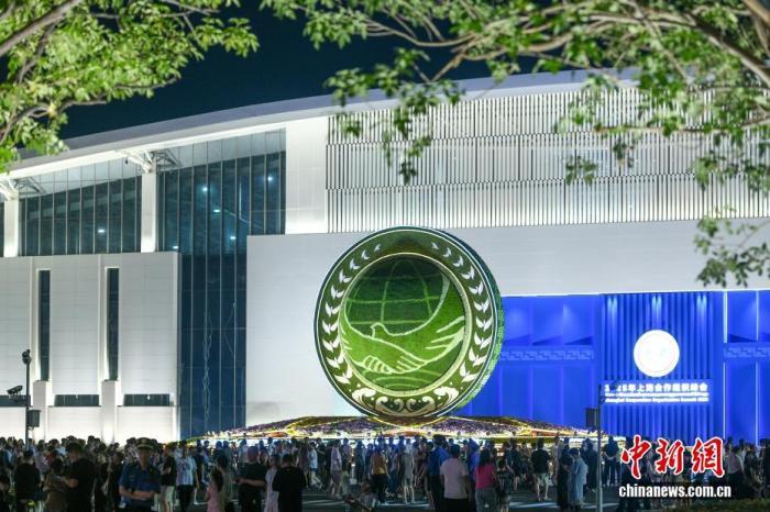 8月28日晚，天津梅江会展中心，“2025年上海合作组织峰会”会场外的主题花坛，吸引了不少市民前来打卡拍照，沉浸式感受上合峰会的浓厚氛围。 中新社记者 佟郁 摄