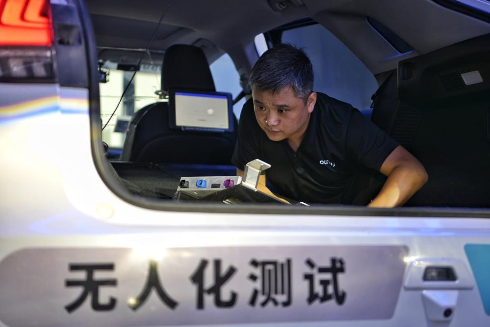 在位于北京的小马智行亦庄运营中心内，工作人员在检查一台自动驾驶测试车辆内搭载的设备（2024年6月19日摄）。新华社记者 辛悦卫 摄