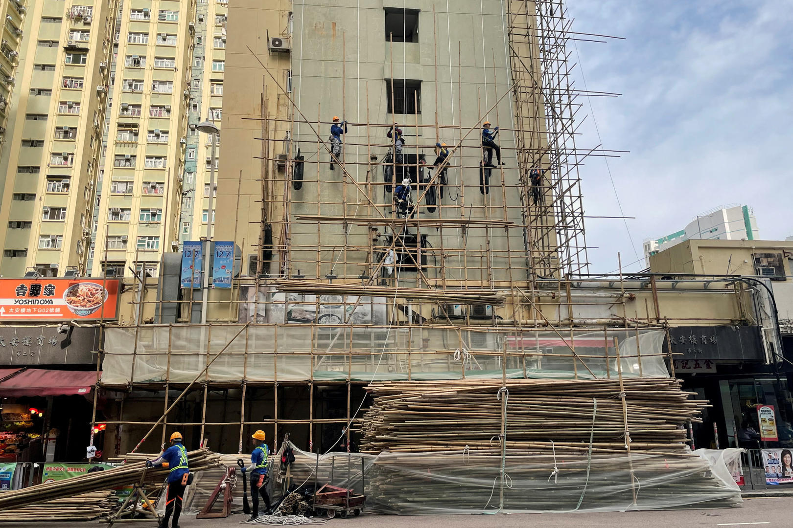 ▲2025年11月27日,香港西湾河区,建筑工人正在一栋大楼外搭建竹制脚手架。图据IC photo