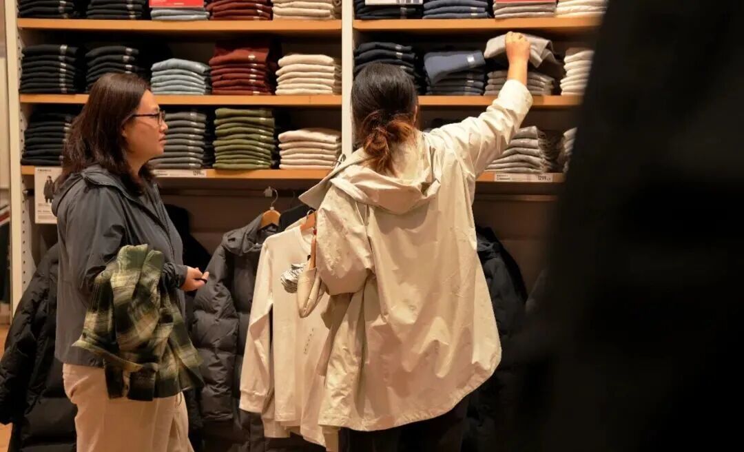 （资料图）10月9日，北京降温明显，市民在一家服装店选购秋冬衣物。中新社记者 张祥毅 摄