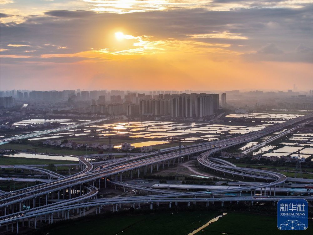 ↑沐浴在落日余晖里的南中高速新隆互通（2024年10月17日摄，无人机照片）。南中高速横跨广州、中山两市，南通珠海、西进江门、东达深圳，串联起粤港澳大湾区核心区域东西南北大通道。通车后从广州南沙15分钟可至中山城区，20分钟可达深圳宝安。新华社记者 刘大伟 摄
