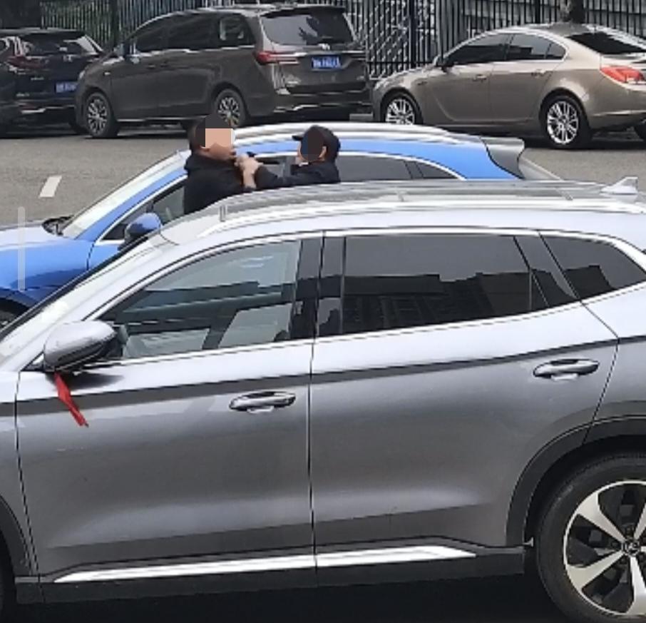 ▲保安和邱某(左)发生拉扯,试图阻止其离开