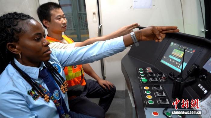 7月28日，伊莎贝拉(左一)与中方司机刘卫红(左二)联合值乘，进行手指口呼作业。　 中新社记者 吕杨 摄