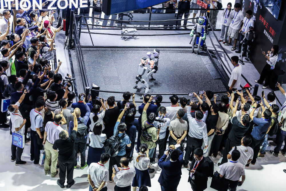 2025年9月25日，在第四届全球数字贸易博览会数智未来主题展区的杭州六小龙专区，观众观看宇树科技的人形机器人进行格斗擂台赛。新华社记者 徐昱 摄