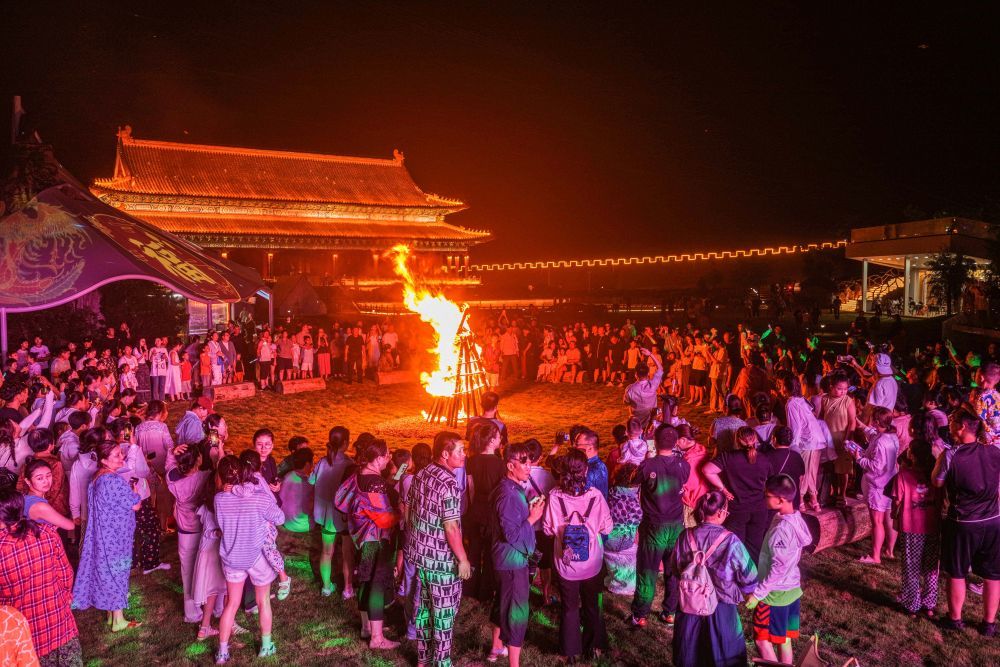 7月20日，在山东省荣成市成山头福如东海景区，游客参加篝火晚会。新华社发（李信君 摄）