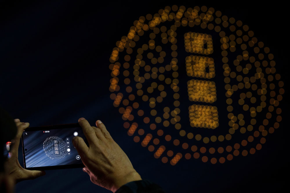 10月6日,游客在黑龙江哈尔滨冰雪大世界园区拍摄无人机表演。新华社记者 张涛 摄