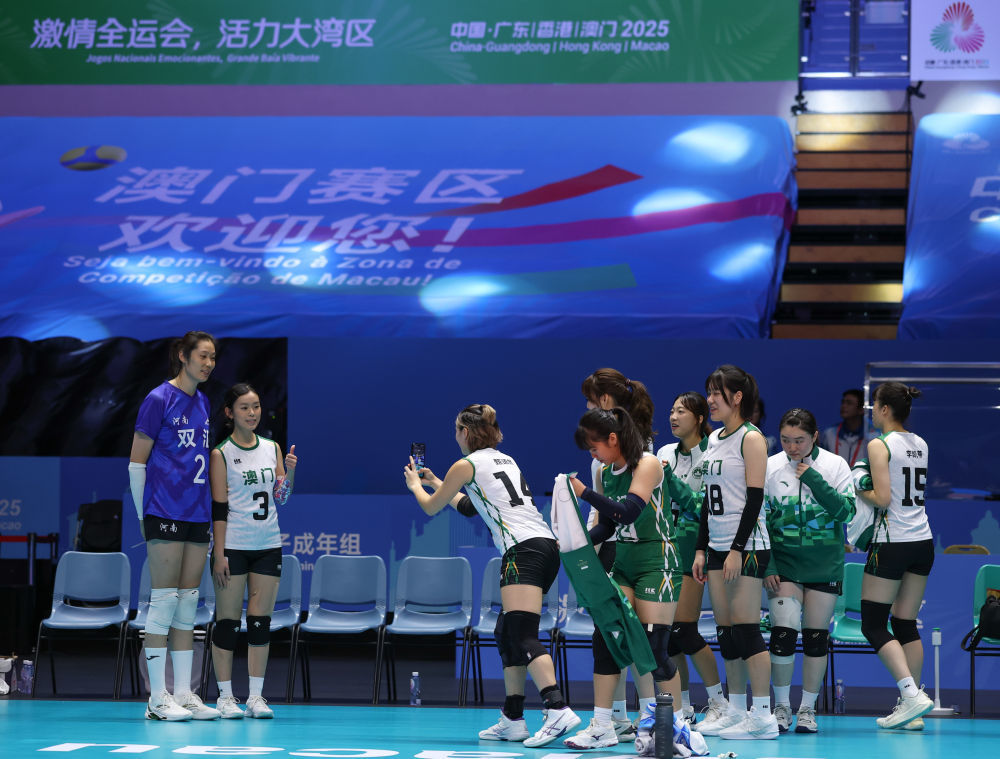 11月11日,澳门队球员在比赛后排队与河南队球员朱婷(左)合影。新华社记者 孙凡越 摄