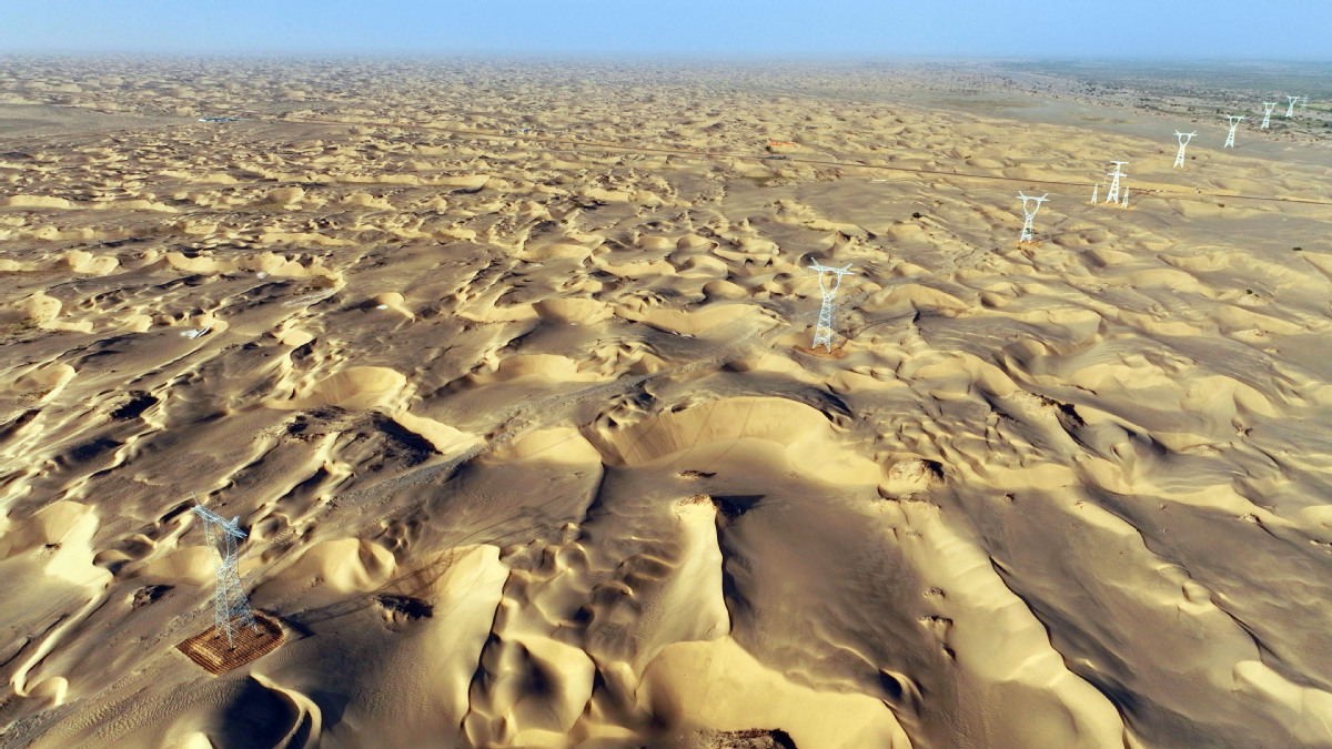 2025年6月25日,民丰—且末—若羌750千伏输电线路工程穿越“死亡之海”塔克拉玛干沙漠。(马元 摄)