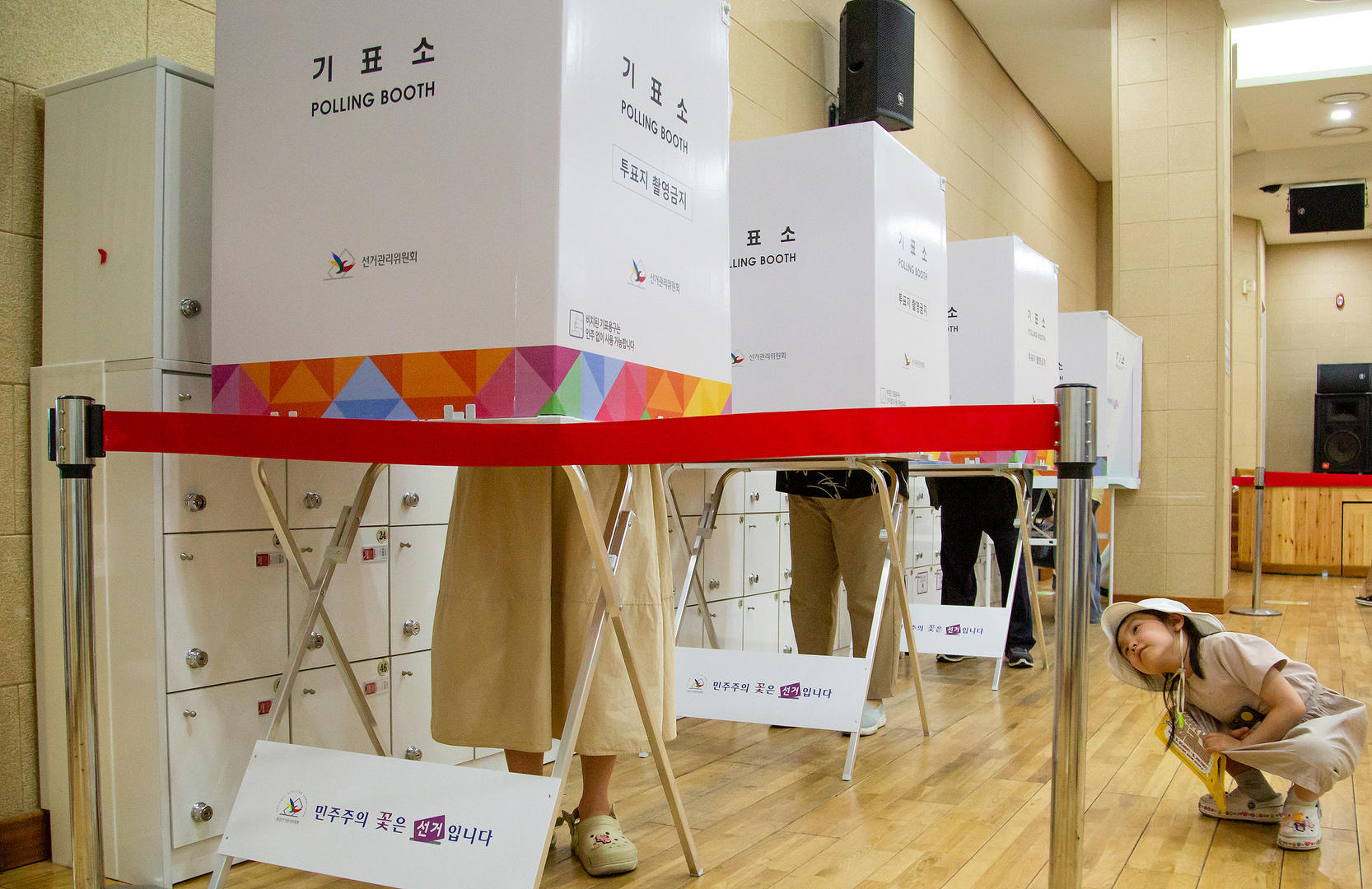 ▲5月30日，在韩国首尔一投票站，一名女孩注视着她的母亲投票 图据视觉中国
