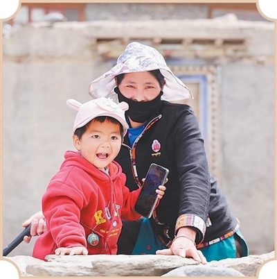 在尼泊尔玉萨村，一名妇女陪着孩子玩耍。环球时报记者 范凌志摄