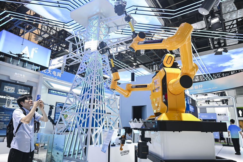 参观者在2025世界人工智能大会展览现场中国南方电网展区拍摄“悟空”带电作业机器人(2025年7月28日摄)。新华社记者 陈浩明 摄
