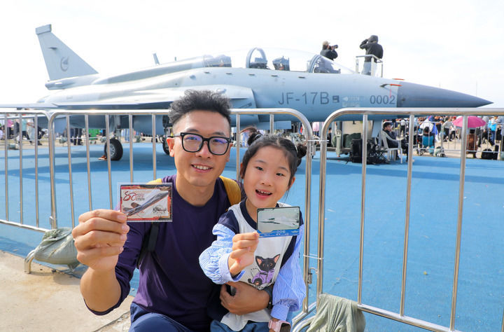 9月19日至23日,2025年长春航空展在长春国际航空博览城举办,吸引诸多参观者观展。图为一对父女在展会现场用航空文创产品卡游致胜空天中国战机卡牌打卡中国战机。新华社记者 许畅 摄