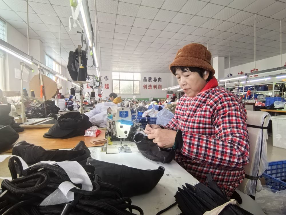 青岛金丰盛泽帽业有限公司的生产车间里，制帽工人们在赶制订单。新华社记者 王欢 摄