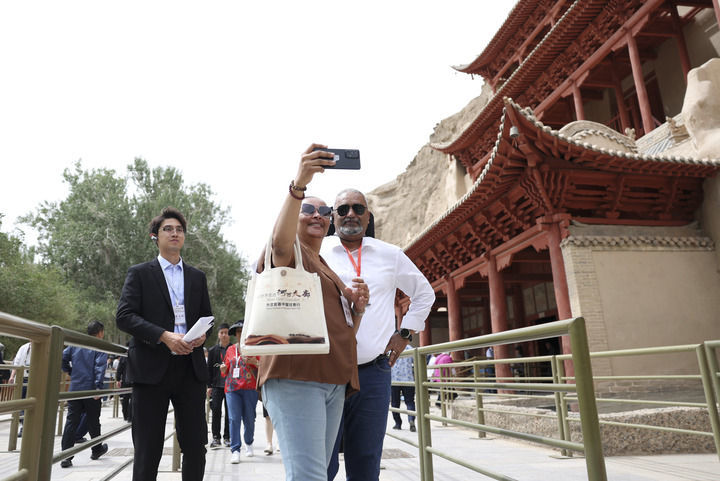 2024年6月7日，前来甘肃调研考察的驻华外交官在敦煌莫高窟九层楼前留影。新华社记者 陈斌 摄