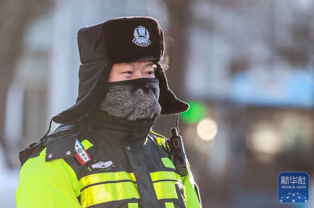 ↑ 12月11日,在黑龙江省伊春市伊美区,一名交警在寒潮中指挥交通。新华社发(李佳星摄)