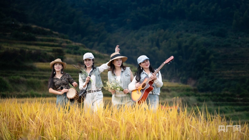 游客在梯田中央弹起吉他(央广网记者 郇康新 摄)