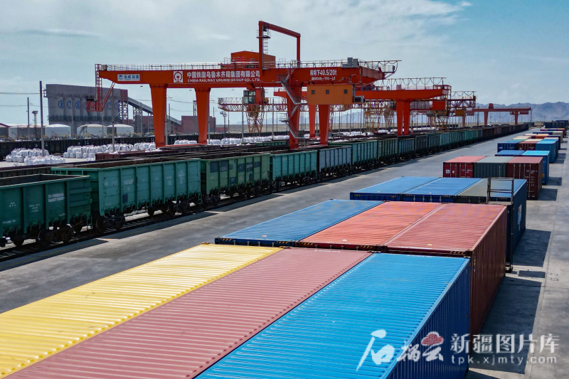 6月24日，阿拉山口站中欧（中亚）班列换装区龙门吊往来穿梭，吊装货物。