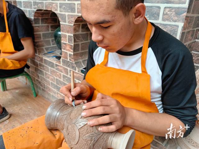 英吉沙县土陶村内,工匠使用传统技法雕刻土陶。南方+ 泠汐 拍摄