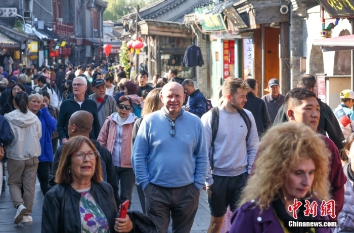 贵寓图：北京什刹海地区ai换脸 刘亦菲，番邦旅客在巷子内参不雅游览。中新社记者 贾天勇 摄