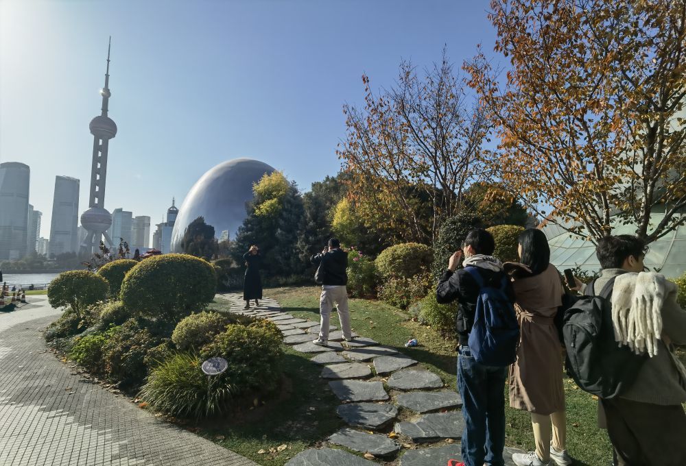 12月9日,一群外国游客在上海北外滩“小巨蛋”前排队拍照。新华社记者 陈爱平 摄