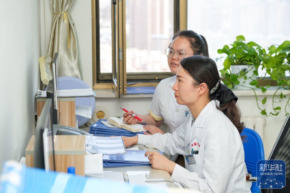 ↑ 在新疆伊犁哈萨克自治州中医医院，江苏援疆医生郭云柯（前）与本地医生一同探讨病例（2025年7月6日摄）。新华社记者 徐宏岩 摄