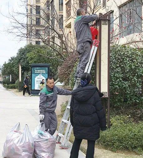 春节周边，图为长沙一小区物业责任主说念主员正在吊挂红灯笼。刘希平 摄