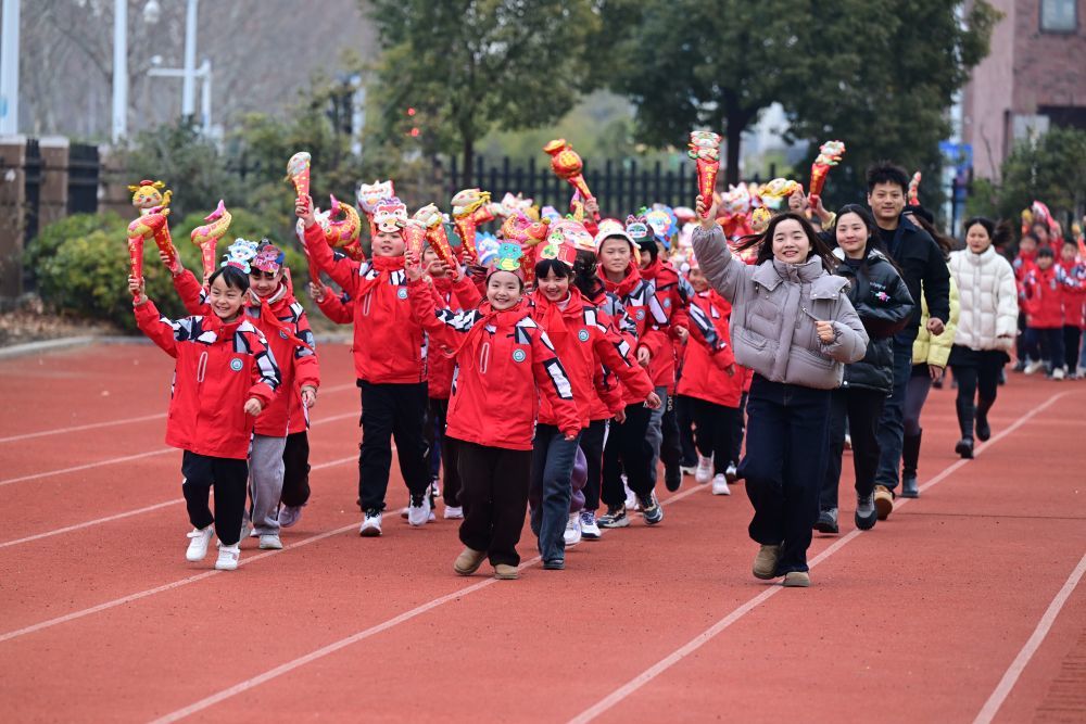2025年2月14日，安徽省合肥市园上园小学喻岗分校师生在开学典礼上进行“贪吃蛇”接力跑活动。新华社记者 周牧 摄