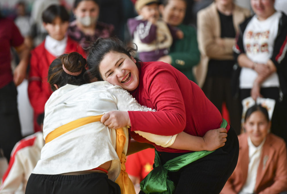4月12日，村民在新疆于田县全民健身中心参加女子摔跤比赛。新华社记者 胡虎虎 摄
