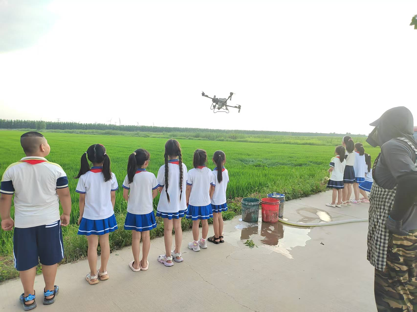 黄庄小学和朝霞路小学学生观察植保无人机喷洒农药（央广网发 天津农学院供图）