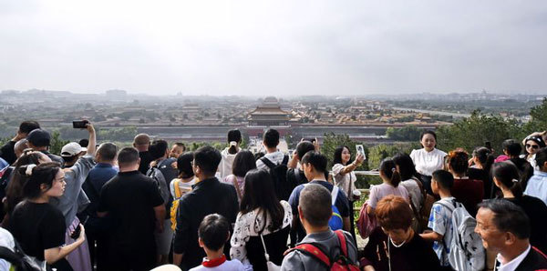 2025年10月4日,游人在北京景山公园观看故宫全景。新华社