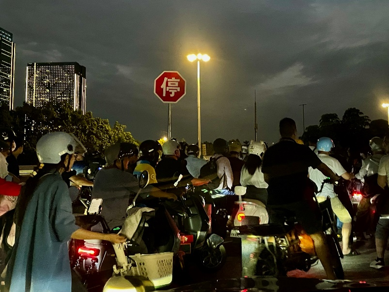 9月23日傍晚,广州洛溪大桥桥头,骑着电瓶车排队上桥的市民。(图/萧奉 摄)
